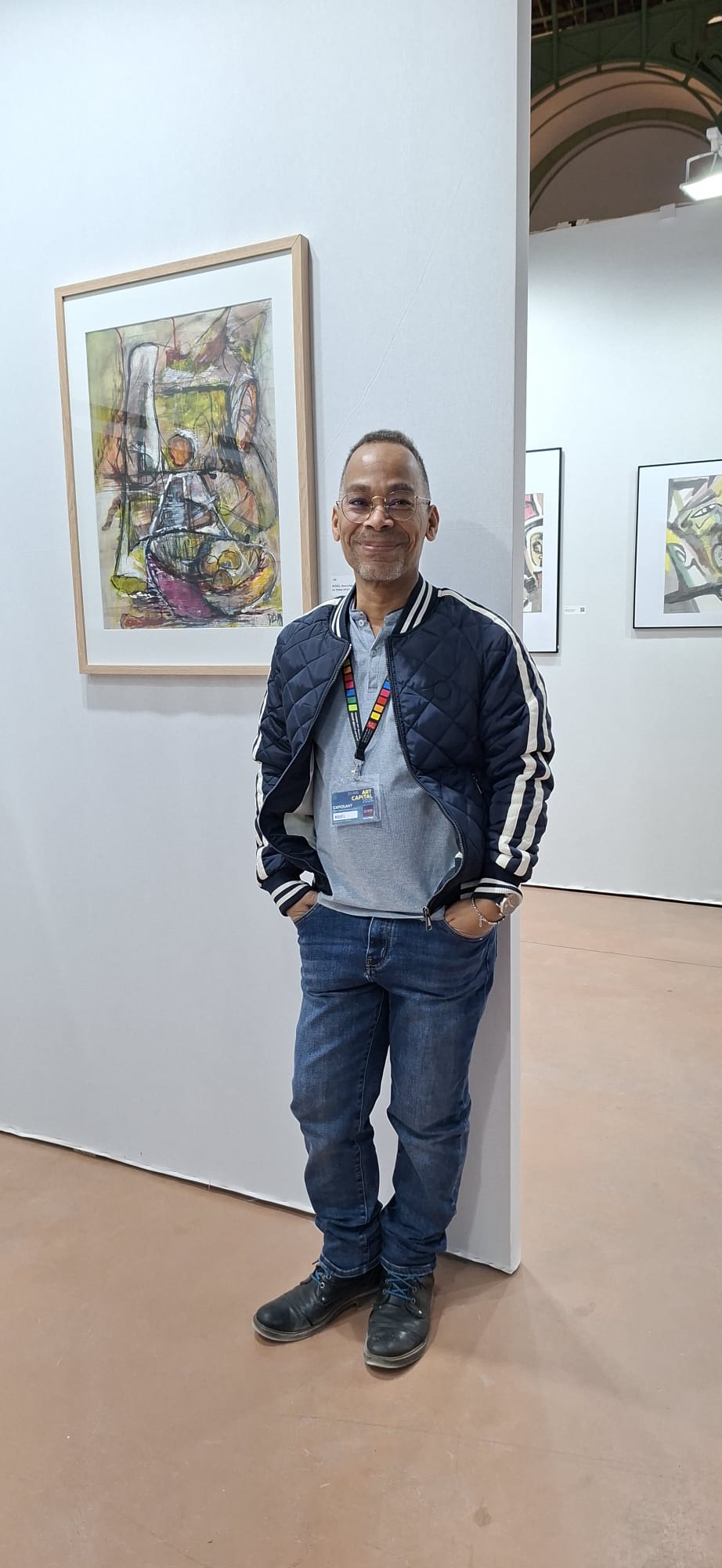 Dominique Kosel devant des œuvres exposées à Art Capital 2026